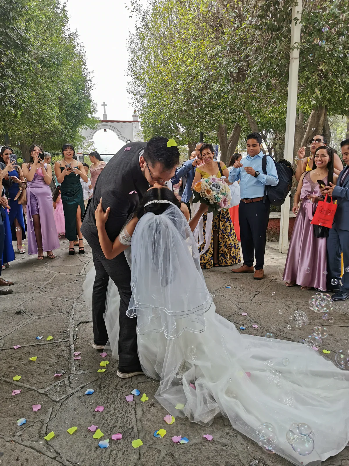 Recién casados besándose en el atrio de la parroquia principal de Coacalco