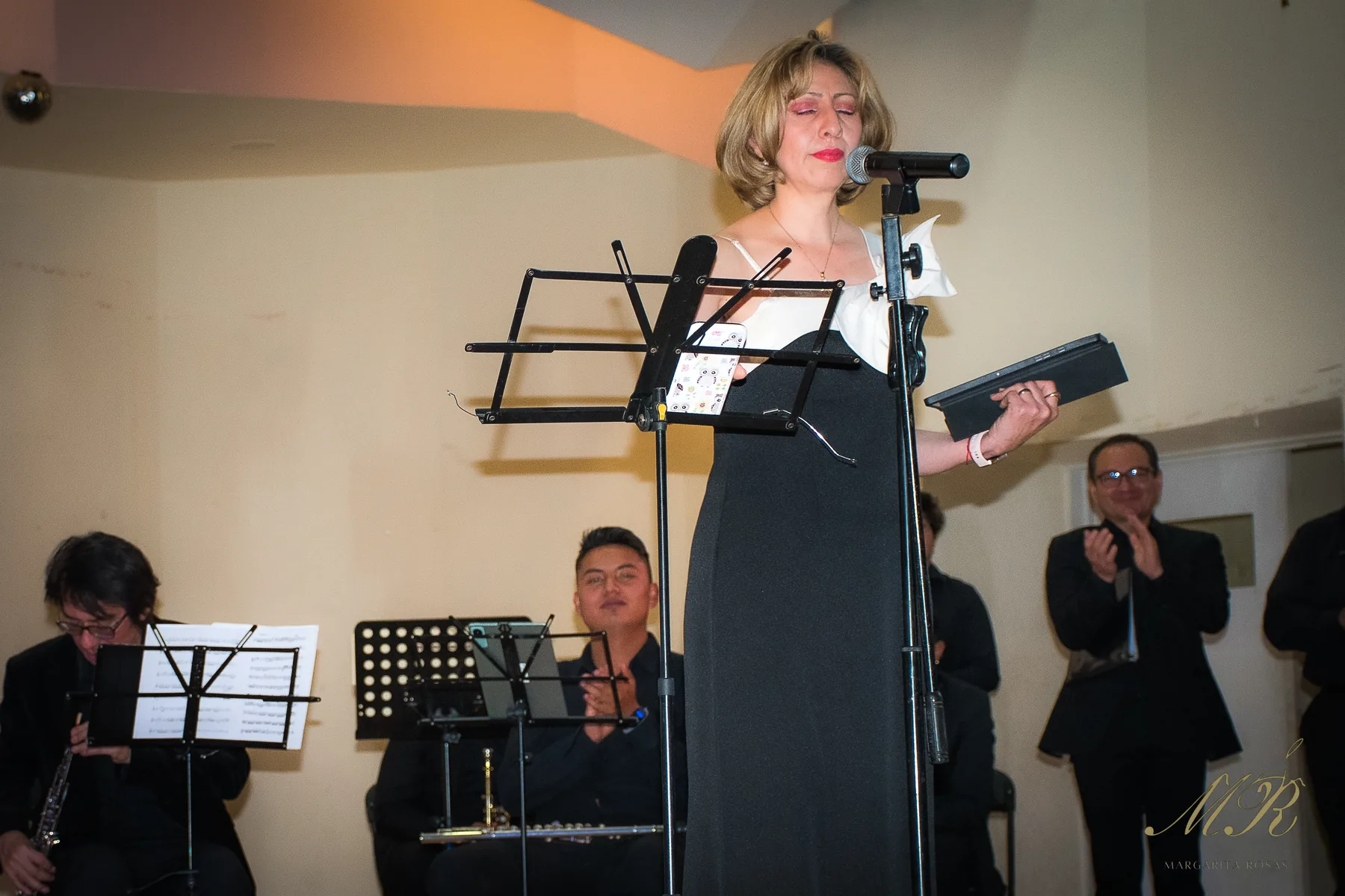 Margarita Rosas cantando acompañada por músicos de alientos