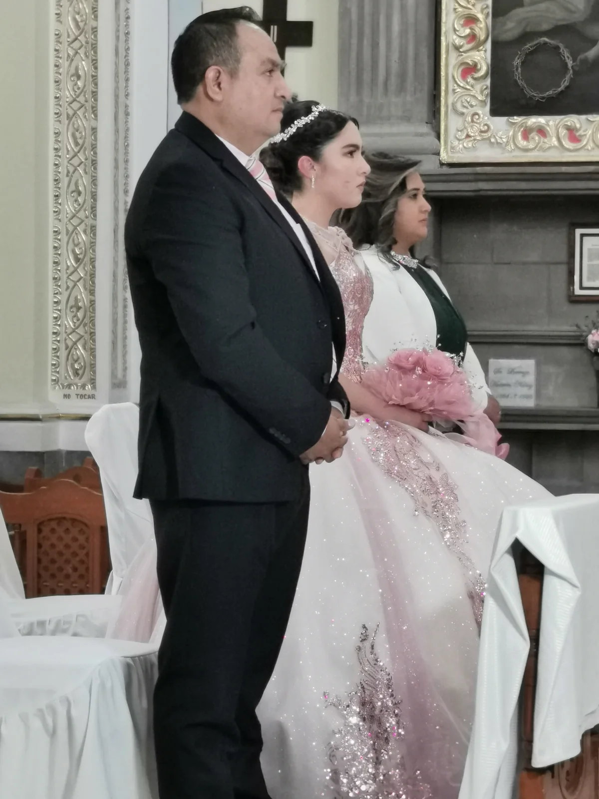 Quinceañera acompañada por su familia durante una misa de XV años