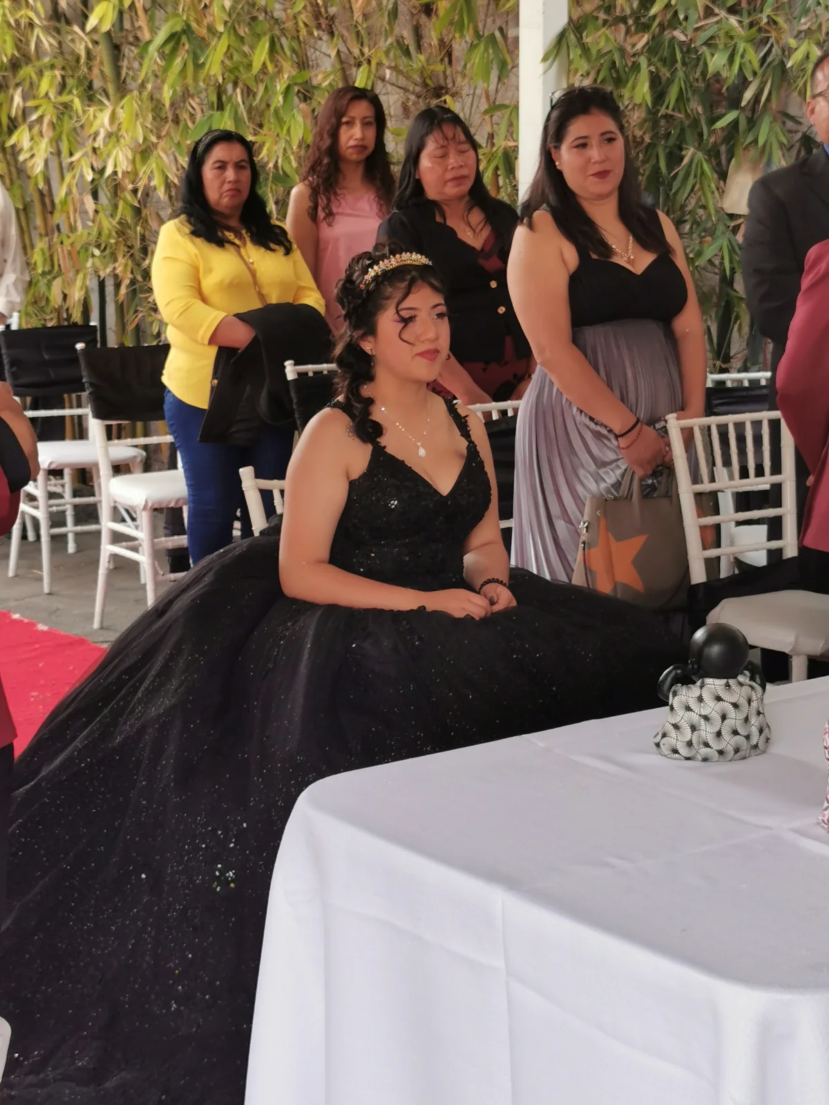 Quinceañera con vestido negro durante su ceremonia de XV años